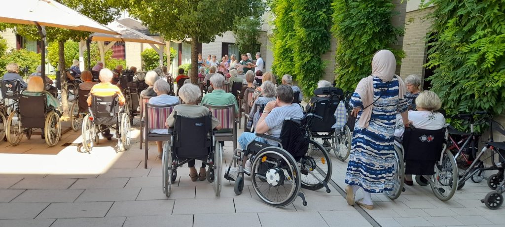 Das Foto zeigt mehrere Bewohnerinnen und Bewohner im Außenbereich bei einer Veranstaltung im Maria Stadler Haus.